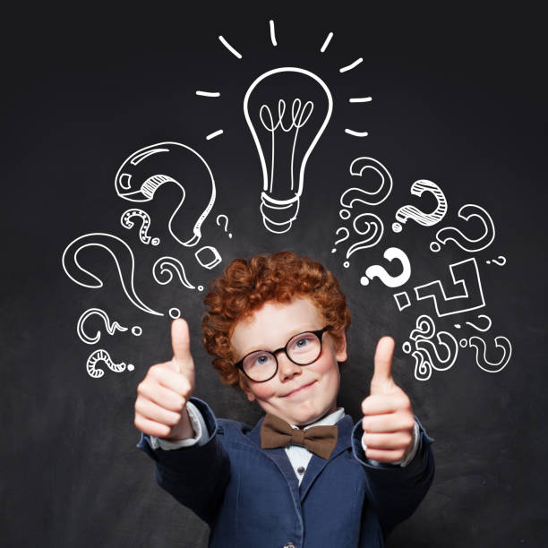 istock Child 9 years old having fun and showing thumb up on blackboard background with lightbulb 1205689944