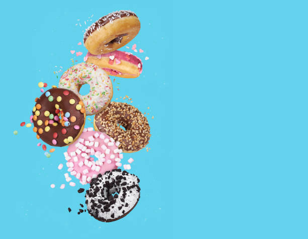 istock flying glazed round doughnuts. Mix of multicolored sweet donuts 1205692324