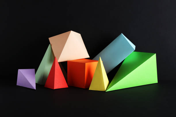 istock Colorful paper geometric figures on black background 1205692963