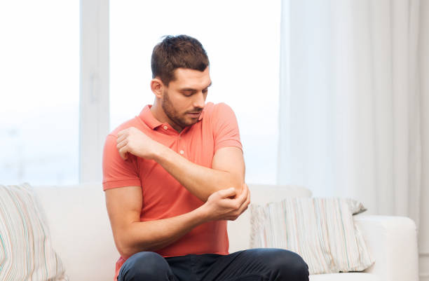 istock unhappy man suffering from pain in hand at home 1205693663