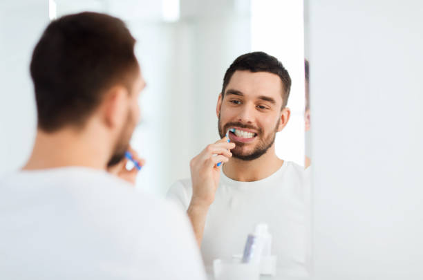istock man with toothbrush cleaning teeth at bathroom 1205693672