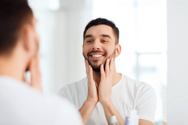 istock happy young man looking to mirror at home bathroom 1205693767