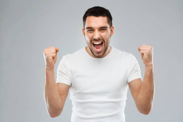 istock young man celebrating victory over gray 1205693846