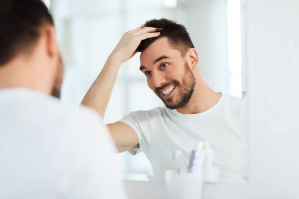 istock happy young man looking to mirror at home bathroom 1205693920