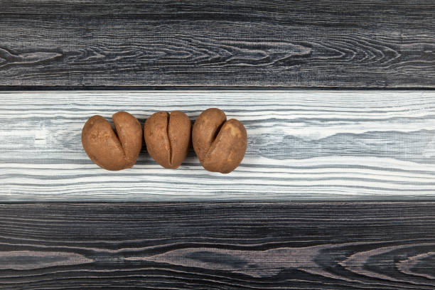 trzy brzydkie ziemniaki w kształcie złamanego serca na czarno-białym drewnianym tle. widok z góry. kopiuj miejsce - heart shape raw potato food individuality zdjęcia i obrazy z banku zdjęć