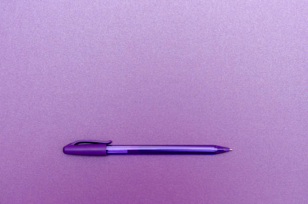 Close-up of colorful pens and fluorescent highlighters resting on a lined paper sheet. Backdrop with selective focus and empty space for text