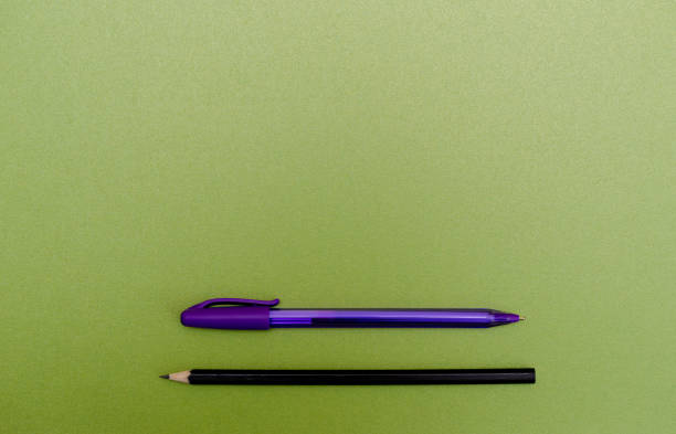 istock Pen and pencil on blank green textured paper 1205696697