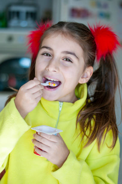 istock Cute girl eating yogurt 1205697743