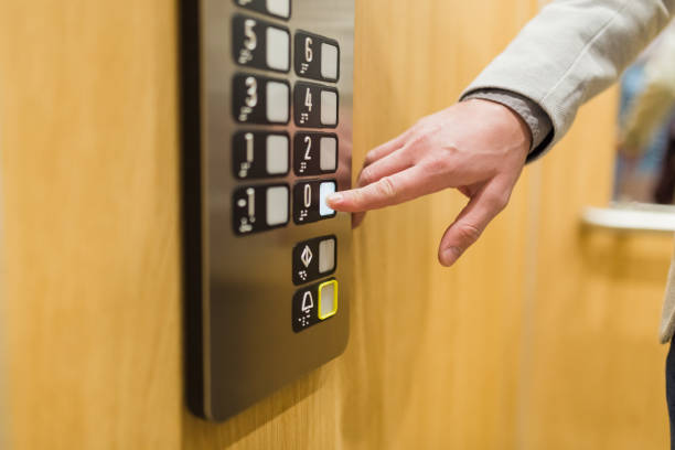 istock Close up of businessman pressing button in modern elevator. 1205699147