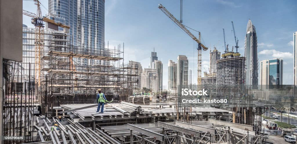 Arbeiter, die an modernen Constraction-Standort arbeiten, arbeiten in Dubai. Schnelle Stadtentwicklung consept - Lizenzfrei Baugewerbe Stock-Foto