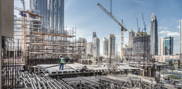 trabalhadores trabalhando em modernos trabalhos de constração em dubai. consept o desenvolvimento urbano rápido - city building - fotografias e filmes do acervo