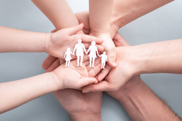 istock Family care concept. Hands with paper silhouette on table. 1205700959
