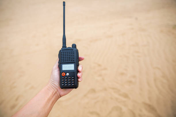 istock man holding Radio / Intercom / Walkie-Talkie in desert 1205701925