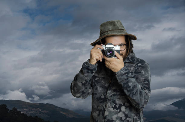 Man taking photo of ocean view sitting on top of the rock
