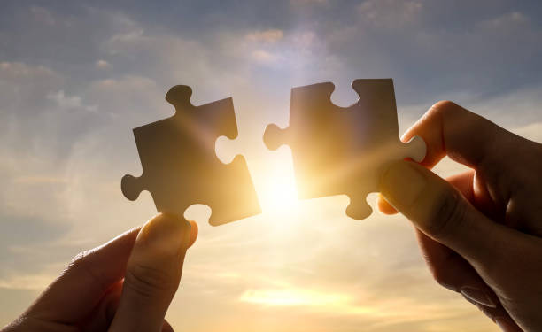 istock The man holds in his hand a jigsaw puzzle. 1205704137
