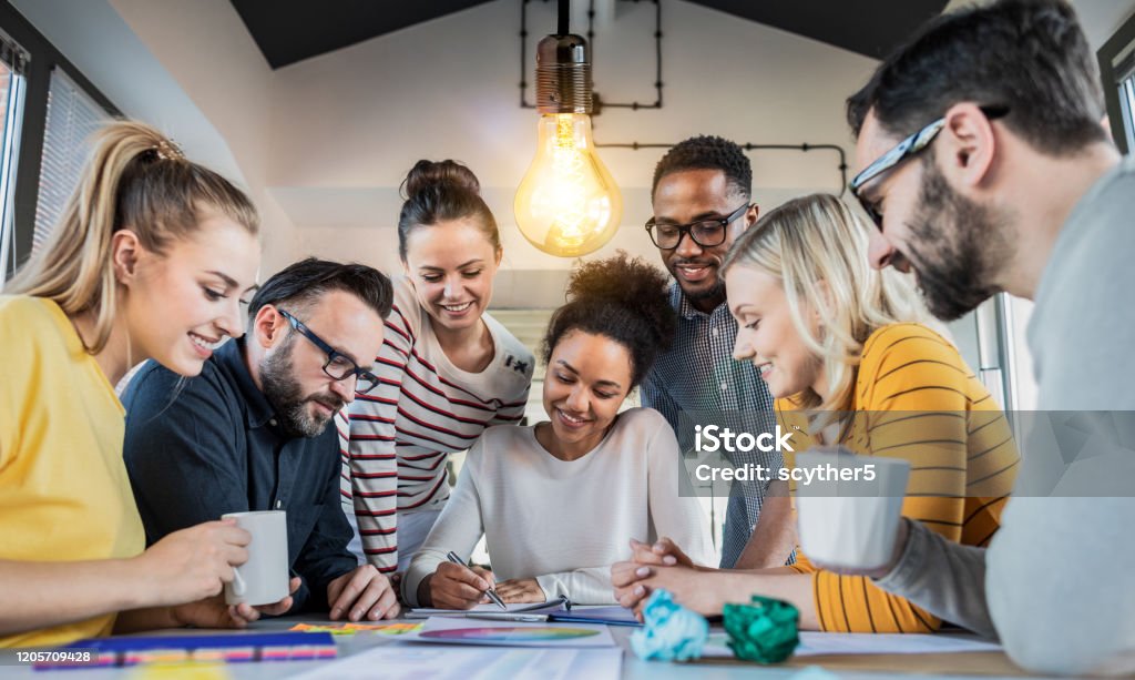 Young creative business people meeting at office. Young business people are discussing together a new startup project. A glowing light bulb as a new idea. Teamwork Stock Photo