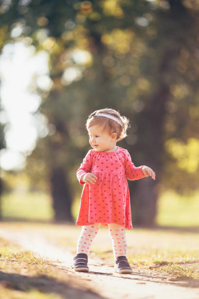 istock Baby girl outdoors in nature taking her first steps 1205711648