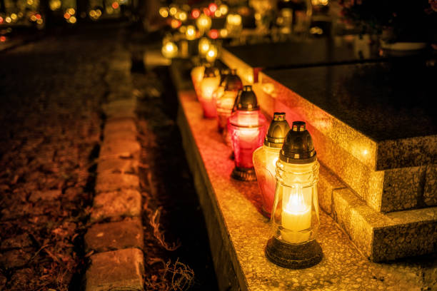 istock Burning candles on graves during All Saints Day 1205714630