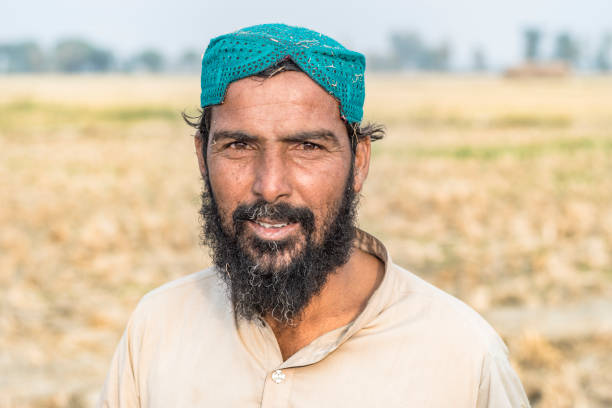 asian farmer is standing at his fields and smiling