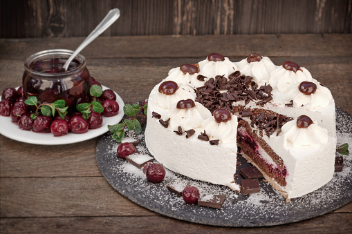 Slice of Schwarzwald cake, delicious creamy fruit and chocolate cake with whipped cream, sour cherry and dark chocolate - Black forest cake
