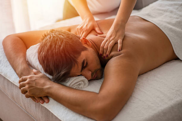 человек, получающий массаж спины от массажиста. - massage therapist massaging sport spa treatment стоковые фото и изображения