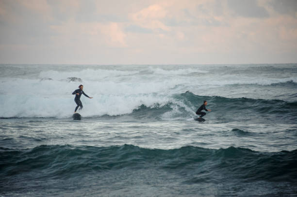 istock Man and woman riding waves on surfboard 1205716793