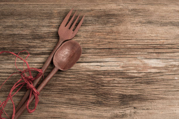 carved spoon and fork on a wooden background with copy space
