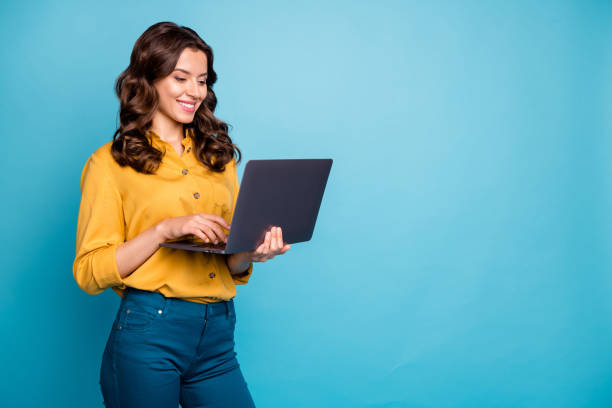 portrait of her she nice attractive lovely cheerful cheery wavy-haired girl holding in hands laptop creating presentation isolated over bright vivid shine vibrant green blue turquoise color background - shirt ethnic ethnicity one person stock-fotos und bilder