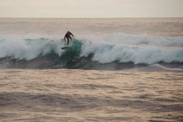 istock Surfer man surfing on top of the wave 1205720103