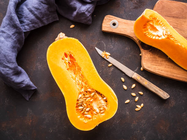 istock Half a butternut squash on a cutting board with a knife, top view 1205720478