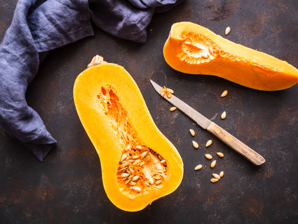 istock Half a butternut squash on a rustic table with a cloth napkin, top view 1205720597