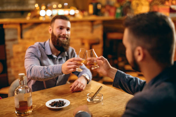 handsome bearded men drinking whiskey - cigar whisky bar cognac imagens e fotografias de stock