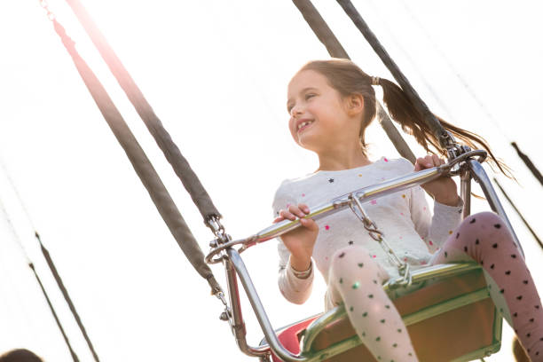 istock Little girl having fun on chain carousel. 1205720912
