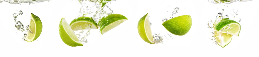 lime dropped into water with splash isolated on white