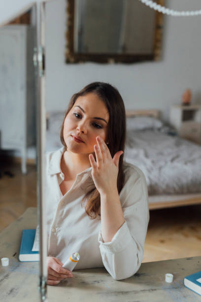 istock Woman Applying Face Cream 1205725031