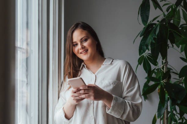 istock Pretty Plus Size Woman Using her Cell Phone 1205725086