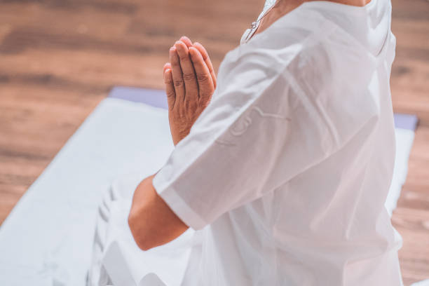 istock Woman meditating in a yoga class 1205725753