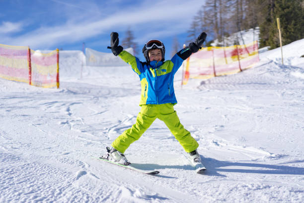 istock cheerful skiing boy having fun on ski slope 1205729172