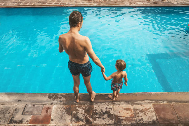 istock Father and son having fun on the pool 1205729841