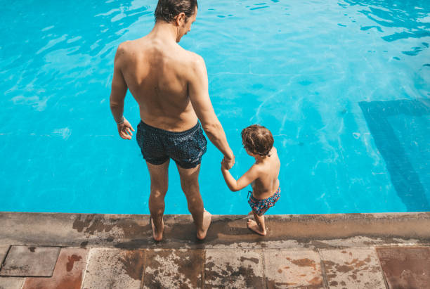 istock Father and son having fun on the pool 1205729859