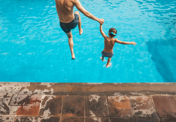 istock Father and son having fun on the pool 1205729889