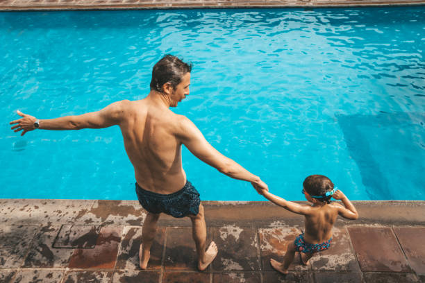 istock Father and son having fun on the pool 1205729892