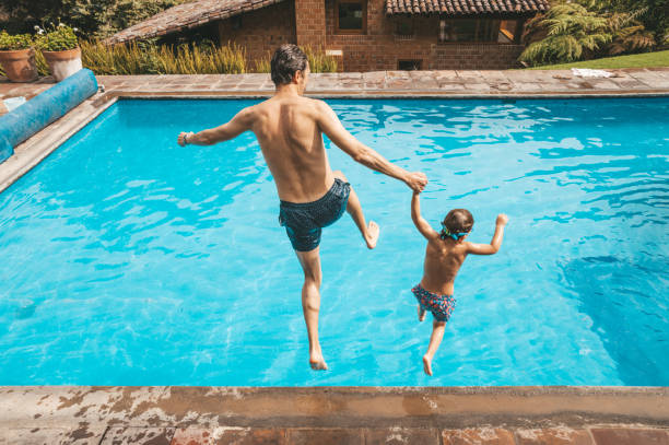 istock Father and son having fun on the pool 1205729904