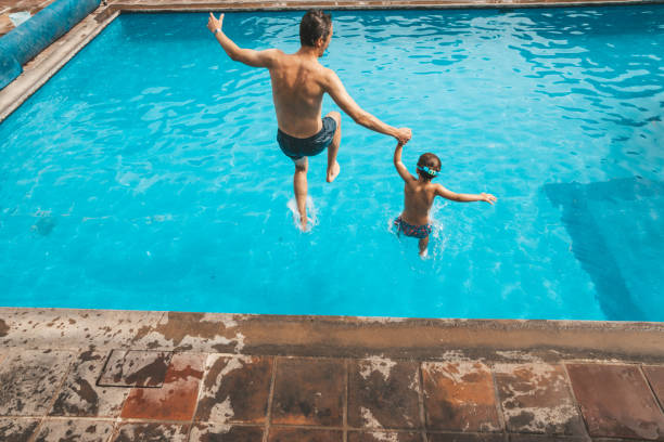 father and son having fun on the pool - tattoo father family son imagens e fotografias de stock