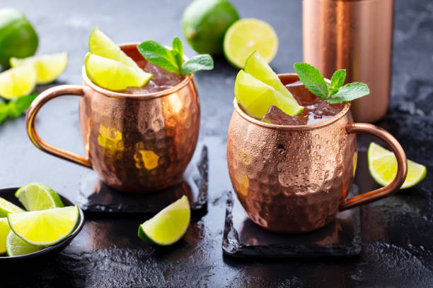 istock Moscow Mules cocktail with ginger beer, vodka, lime and mint. Dark background. Close up. 1205730982
