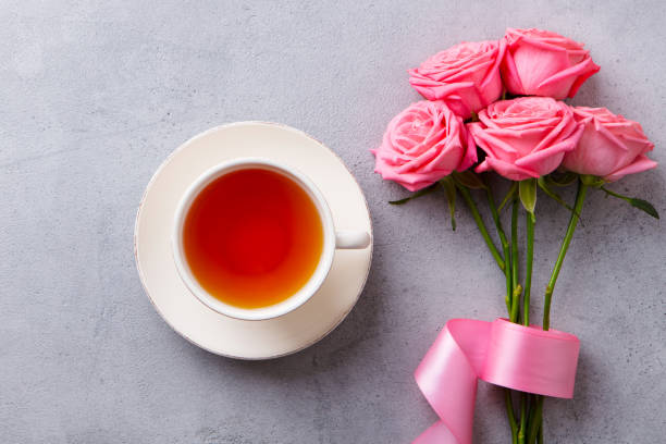 istock Cup of tea with fresh flowers on grey background. Copy space. Top view. 1205731287
