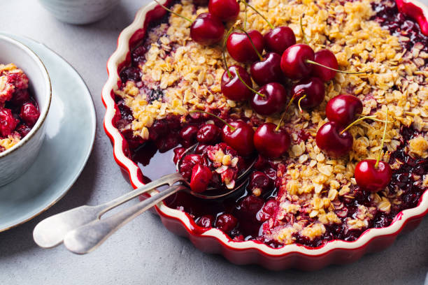 istock Cherry, red berry crumble in baking dish. Grey stone background. Close up. 1205731446