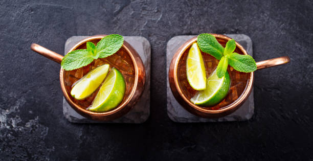 istock Cold Moscow Mules cocktail with ginger beer, vodka, lime and mint. Grey stone background. Top view. 1205732185