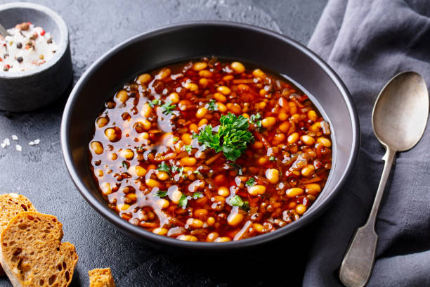 Bean soup in a black bowl. Dark background. Close up. Bean soup in a black bowl. Dark background. Close up. soup lentil healthy eating dishware stock pictures, royalty-free photos & images