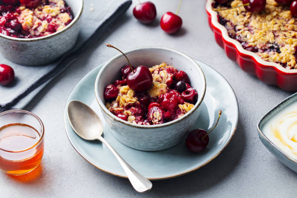 istock Cherry, red berry crumble in bowl. Grey stone background. Close up. 1205733448